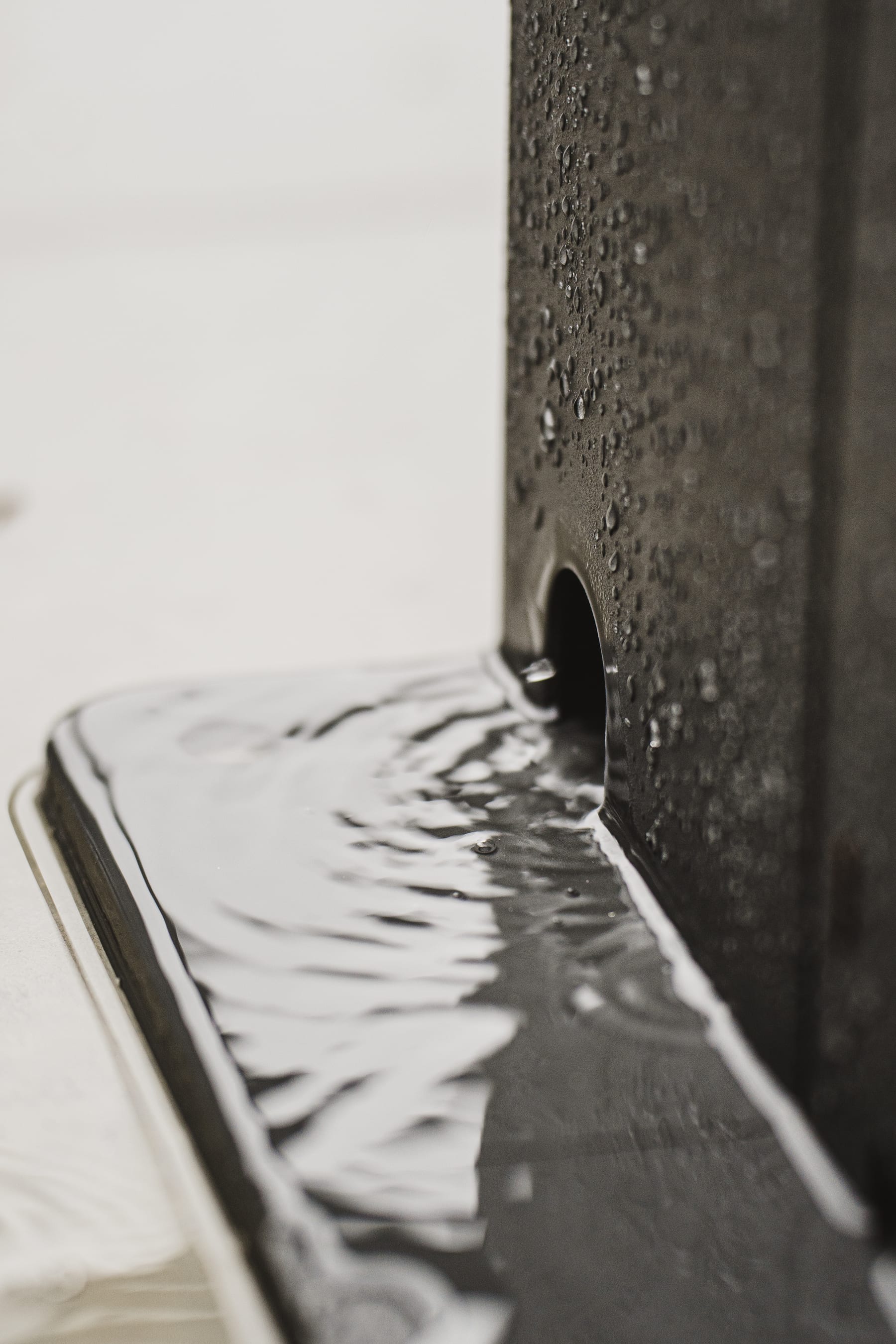 Lames fermées de la Pergola 4 Pro sous une pluie soutenue, eau évacuée proprement vers la gouttière interne de la structure