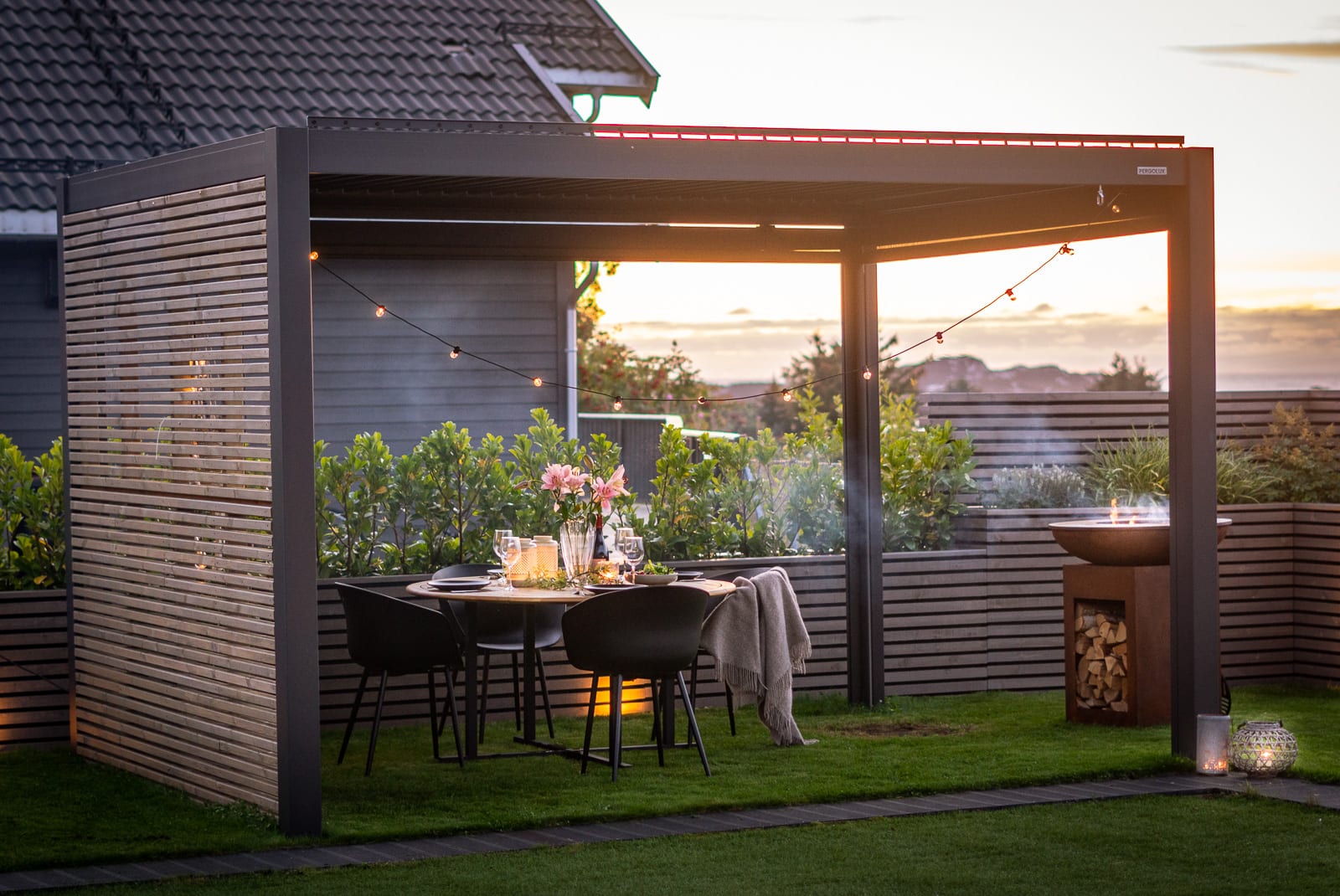 Lâminas de pérgola em ângulo intermediário bloqueando sol de tarde em área externa com projetor ligado