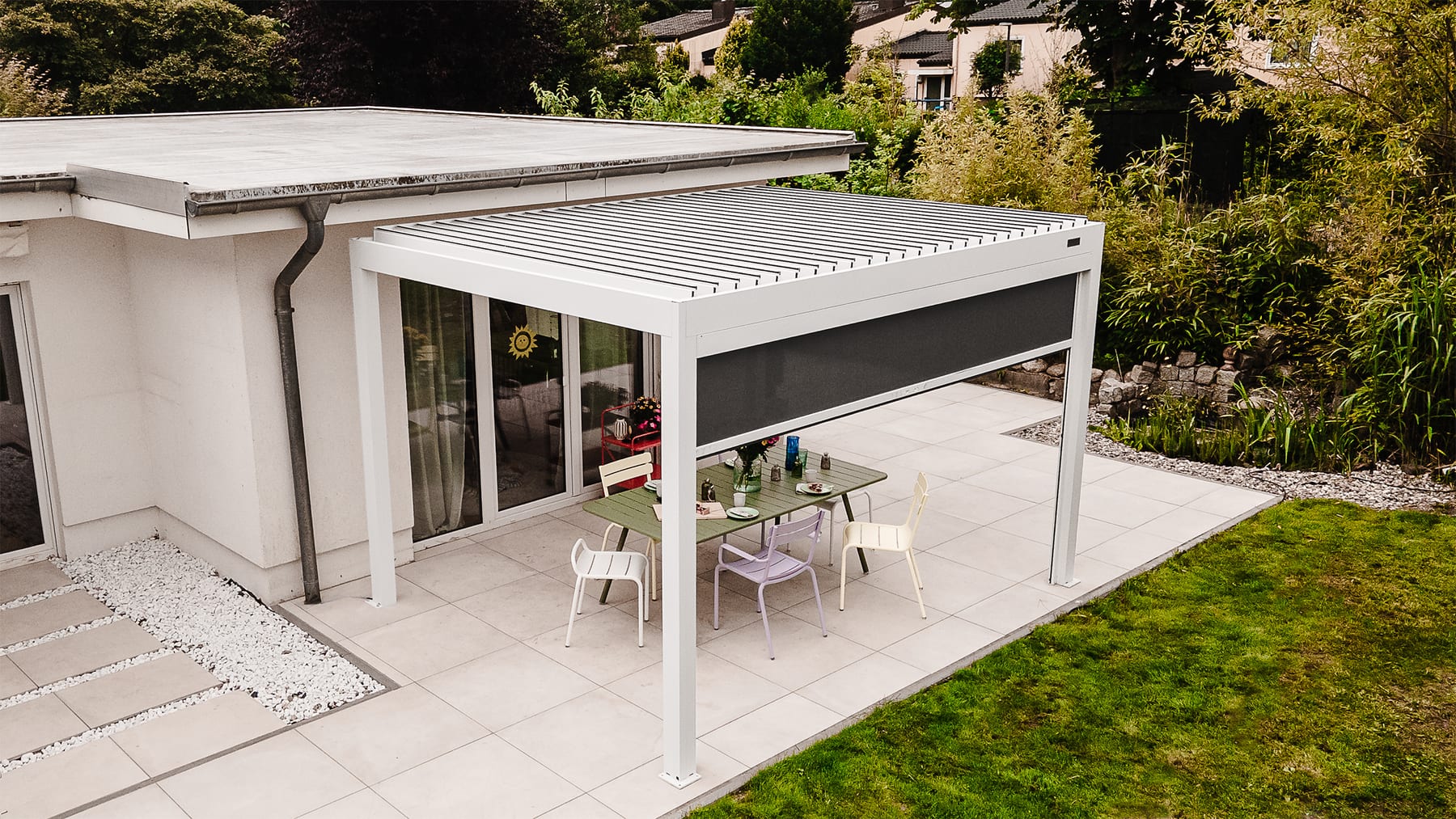 Pergola 4 Pro PERGOLUX en aluminium blanc sur grande terrasse moderne, lames en position mi-ouverte, soirée ensoleillée