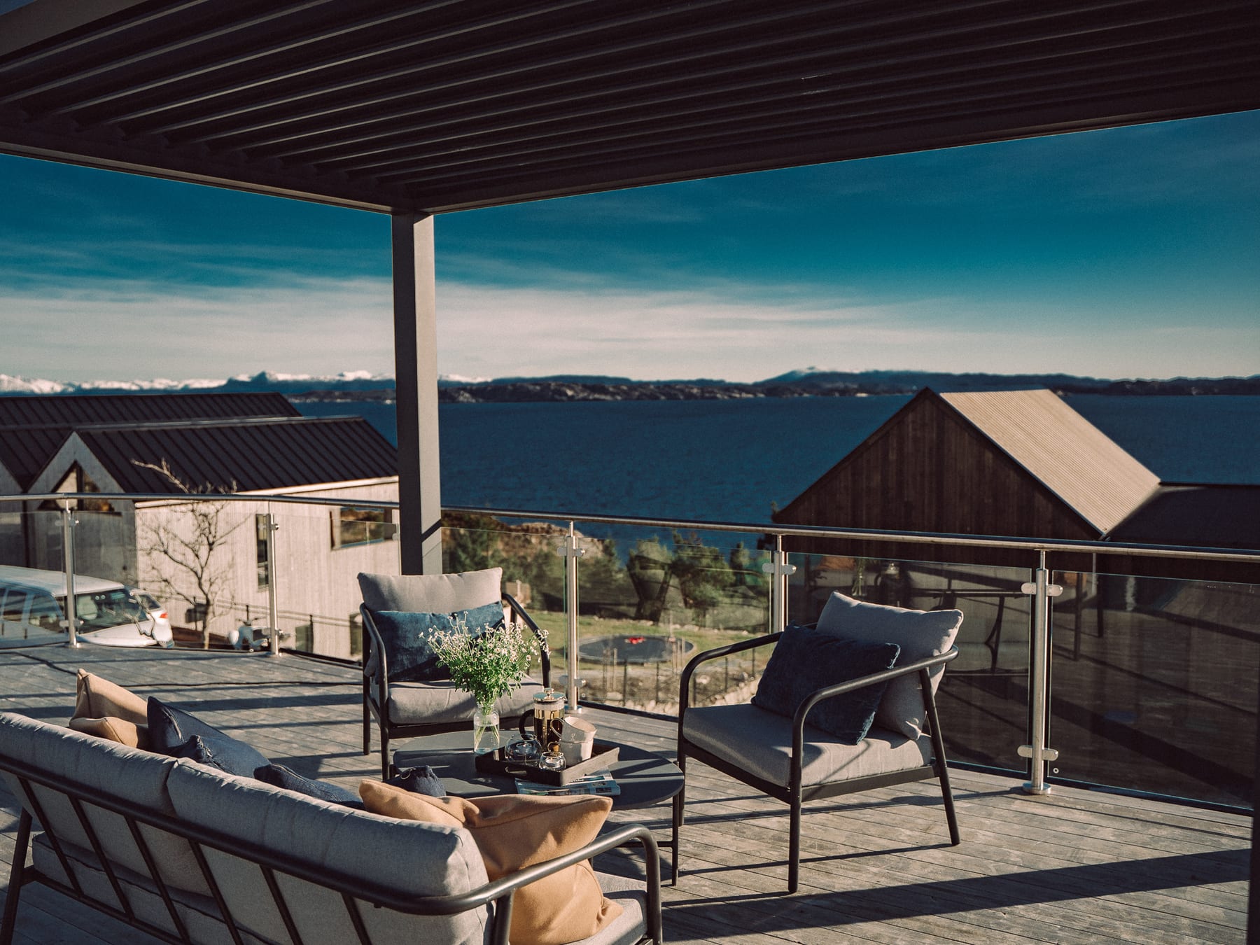 Vue aérienne d'une terrasse avec Pergola 4 Pro Max face à la façade atlantique, lames ouvertes par ciel bleu hivernal